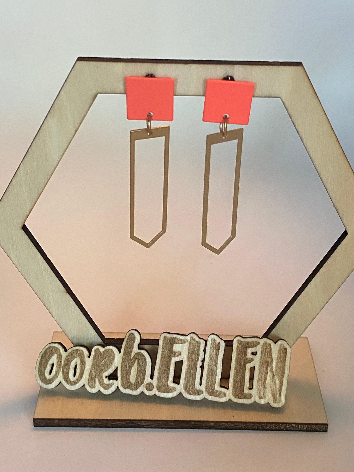 Gouden paperclip aan fluo oranje oorknopje