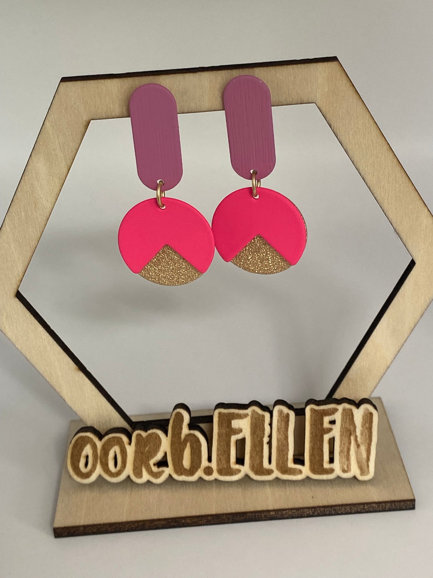 Gouden cirkel aan volle ovalen paarse oorknoppen + fluoroze cirkel met hap uit