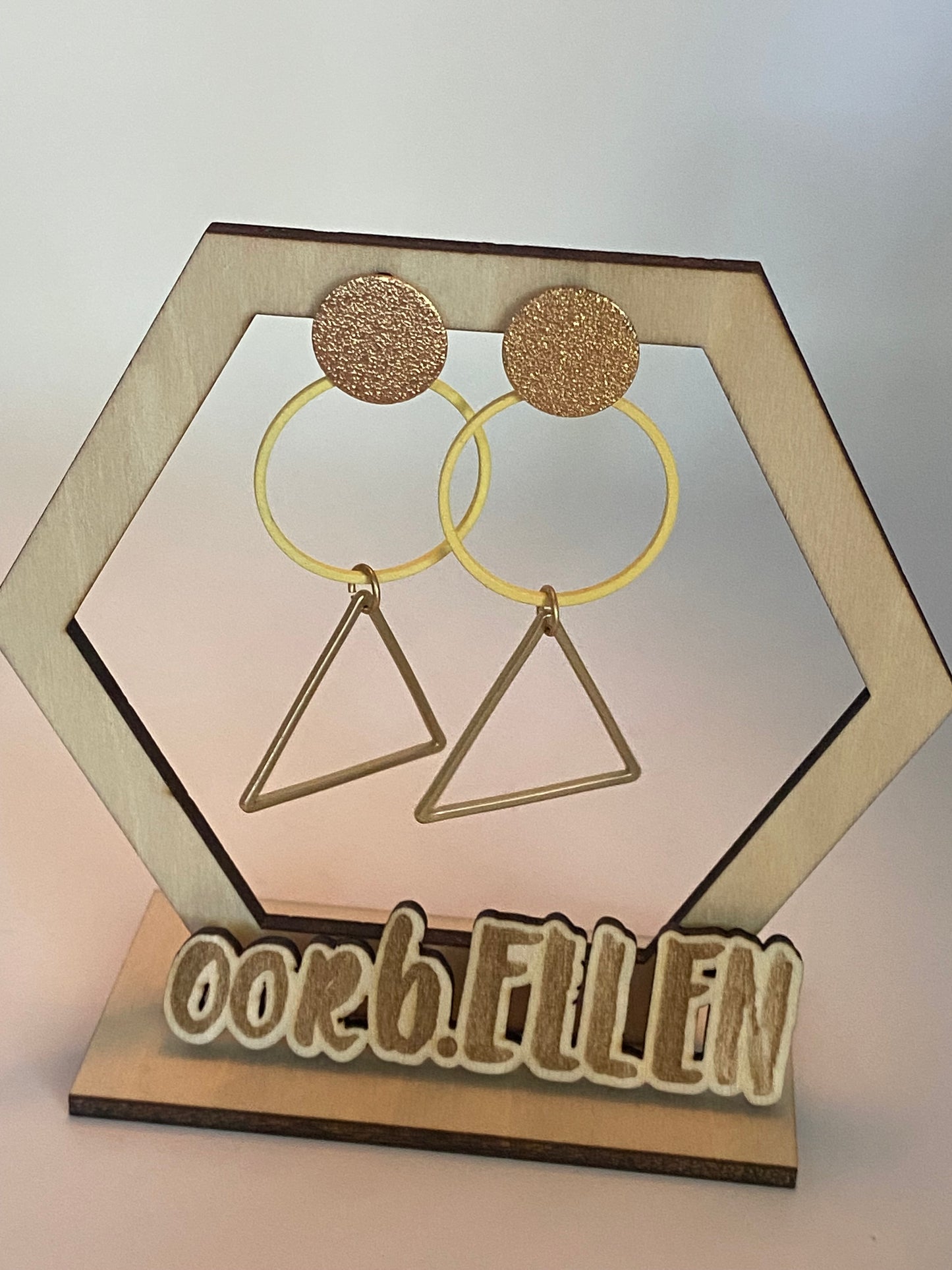 Gouden driehoeken aan pastelgele cirkel