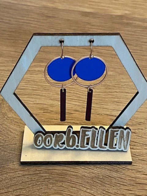 hemelsblauwe cirkel in mat gouden cirkel en staafje donkere porto