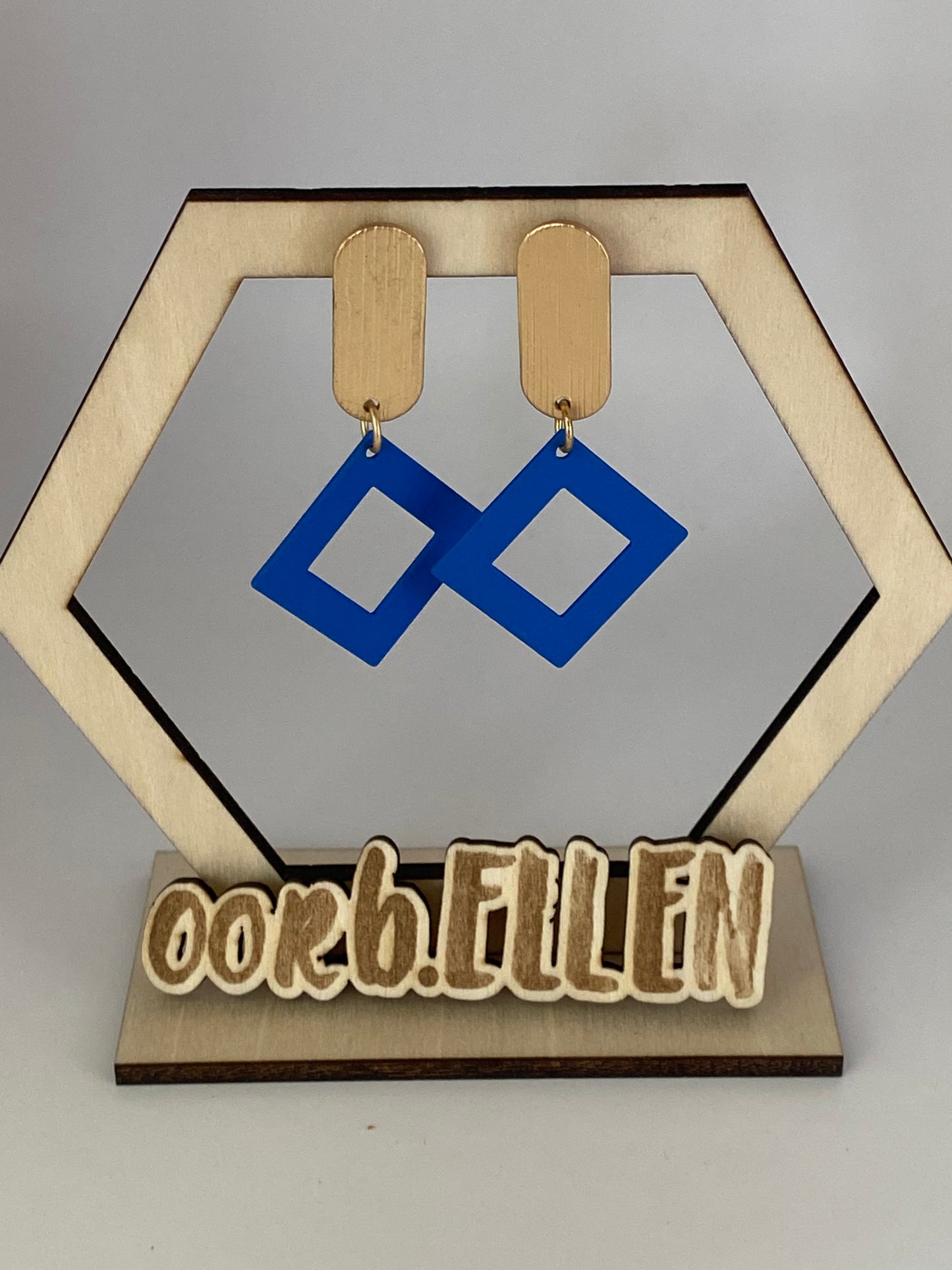 Blauwe open ruit aan gouden ovalen knop